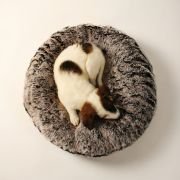 dog curled up in round fur dog bed with thick plush fur